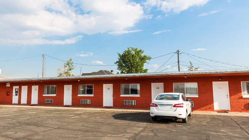 motel en ruta durante road trip en EEUU — entrada iluminada de noche con auto estacionado